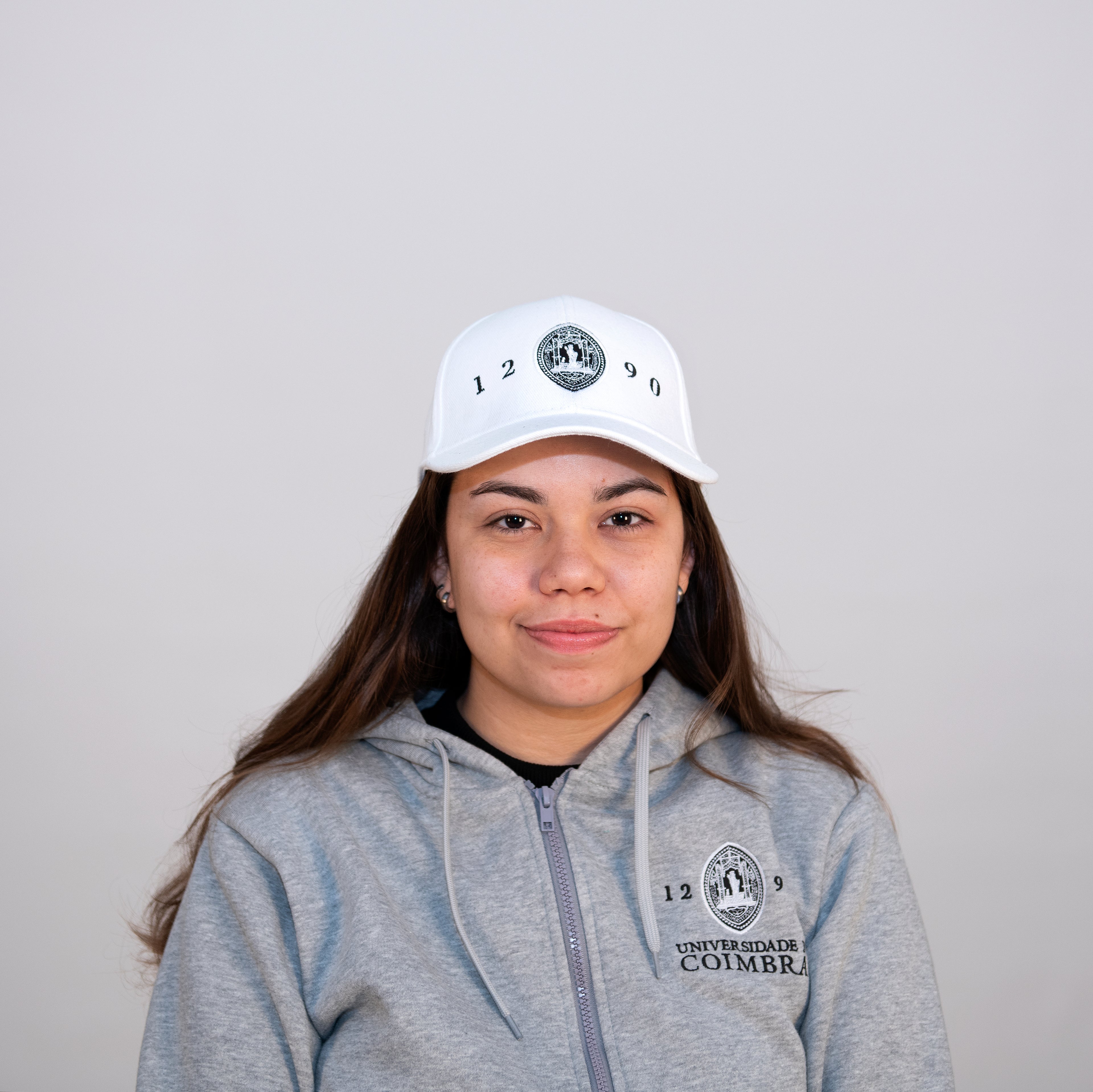 Boné Branco para adulto com a insígnia da Universidade de Coimbra.