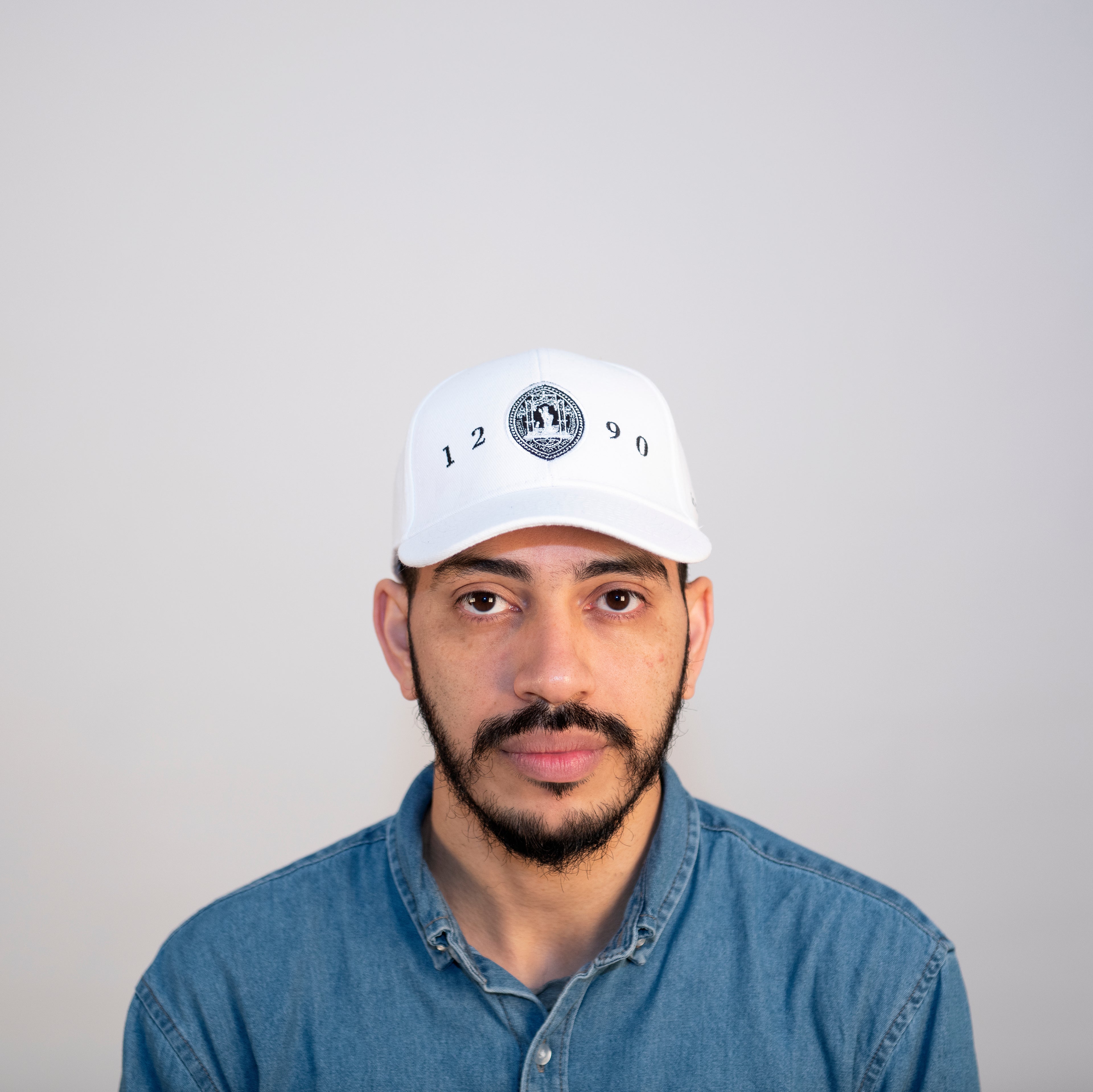 Boné Branco para adulto com a insígnia da Universidade de Coimbra.