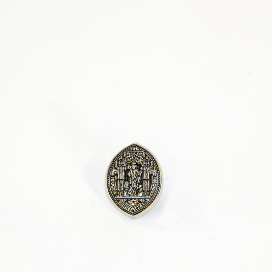 Pin de metal com a insígnia da Universidade de Coimbra. Figura da Minerva ou Sapiência.