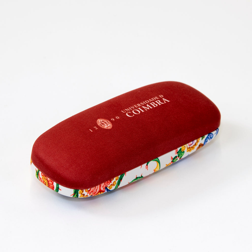 Caixa para óculos de cor vermelha escura na base e com reprodução da pintura do teto da Capela de São Miguel na parte de cima.