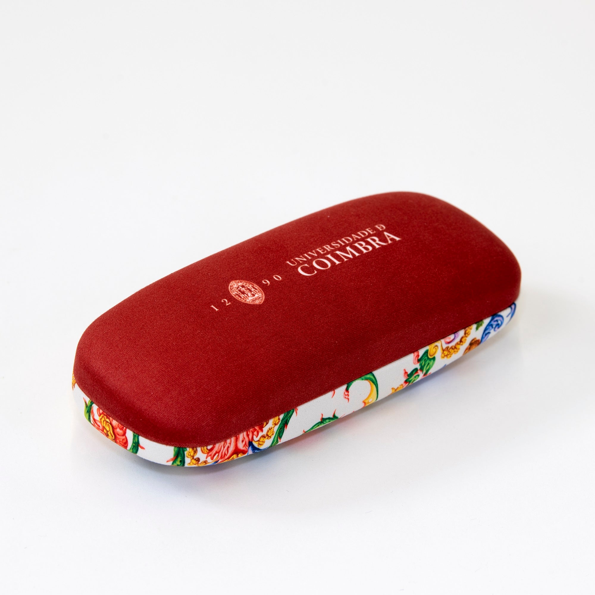 Caixa para óculos de cor vermelha escura na base e com reprodução da pintura do teto da Capela de São Miguel na parte de cima.